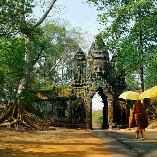 Monks with umbrella walking in Angkor Wat, Cambodia