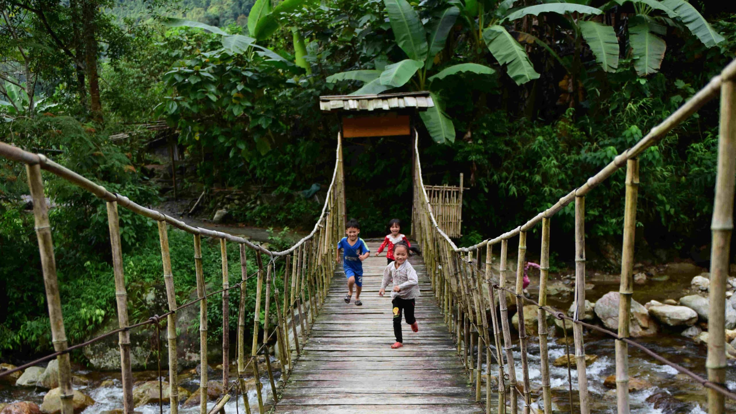 Go Indochine kids playing on bridge Vietnam